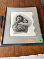 Photo of framed print 'Woman & Child' showing woman and child in fur-lined hoods, with gray frame and double mat.
