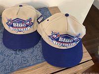 Two beige and blue Blue Jays 1992/93 Champions caps side by side showing front