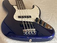 Close-up of guitar body front showing pickguard, bridge, controls and finish