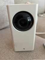 Front view of the Wyze Cam Pan camera showing the black dome-shaped lens on a white rectangular body.