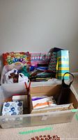 Full view of one storage bin showing assorted Christmas gift bags, wrapping paper, and tissue paper inside.