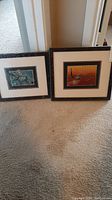 View of two framed and matted pictures leaning against a door showing their size and framing style