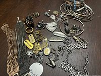 Full view of a variety of fashion charms, bracelets, and stacking bangles on a wooden surface, showing metallic textures and diverse charm styles.