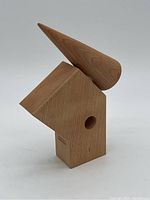 Front view of the designer wooden pepper mill with an abstract design, showing the conical top and hole in base section.