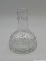 Full view of the decanter showing the wide base and tapered neck with textured pattern.