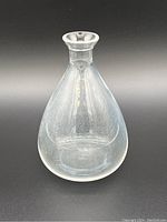 Clear glass Lalique decanter, broad base, tapered neck, flared lip, signed on bottom, 7.5 inches tall, some surface haze, no damages.
