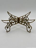 Solid copper folding stand assembled, showing interlocking intricately cut legs