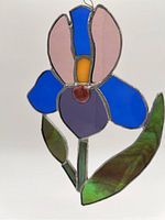 Close-up of stained glass flower suncatcher showing color and metal framing details