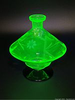 Uranium glass vase glowing bright green under UV light showing overall shape and design.
