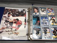 Photo showing a binder sleeve page with hockey cards including an autographed card and various player cards from different teams.