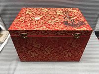 Photo of closed red decorative box with gold pattern and black calligraphy on lid
