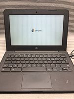 HP Chromebook laptop powered on, displaying initial Chrome OS loading screen with Chrome logo.