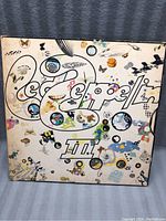 Front cover of the Led Zeppelin III album with colorful decorated 'Led Zeppelin' letters and the III symbol