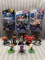 Lot of 11 Disney Infinity figures including Marvel and Disney characters, showing both packed and unpacked items.