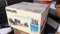 Photo of sealed Philips HTS3400/37 DVD 5.1 channel home theater system box showing product image and branding.