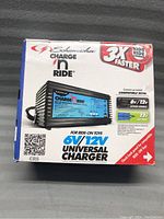 Front view of original boxed Schumacher Charge and Ride 6/12 Volt Universal Charger showing branding, specifications and compatibility.