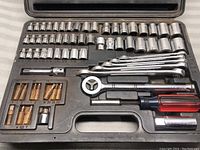 Top-down view of the full tool case showing all sockets, wrenches, ratcheting wrench, screwdriver handle, and hex bit sockets.