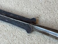 Close-up of blade-to-ferrule junction showing central ridge and patina