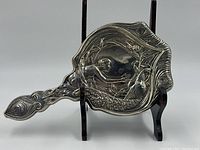 Full front view of mirror on display stand showing overall shape and decoration