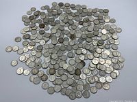 Wide view of scattered silver dimes on white background