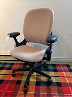 Front three-quarter view of the chair showing seat, backrest, armrests, base and casters