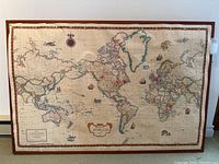 Full view of the vintage-style world map mounted on cork board with visible borders and map details.
