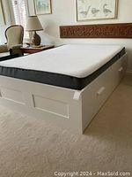 Full view of white Brimnes bed frame with mattress in room