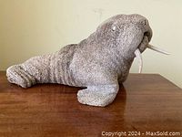 Overall right-side profile of the walrus sculpture on wooden surface