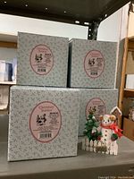 Four Cherished Teddies boxed figurines on shelf with one out of box showing details