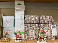 Boxed Cherished Teddies figurines stacked and two visible unboxed bears on a surface.
