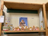 Wide view showing eight Cherished Teddies figurines arranged on wooden shelf, varying from 1 to 5 inches tall, and a Cherished Teddies collectors magazine positioned in the background.
