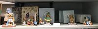Nine Cherished Teddies bear figurines on display shelf with original boxes behind them