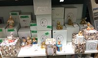 Display of multiple Cherished Teddies figurines with packaging boxes labeled with numbers and names.