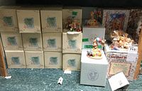 Overall shelf view showing the stacked boxes, two displayed figurines, and a boxed 5 figurine collectible set.