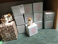 Photo of Cherished Teddies figurines displayed with multiple decorative boxes stacked behind them.