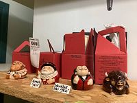 Four ceramic face pots displayed alongside their original red cardboard boxes, each box labeled with Kevin Francis Facepots branding.