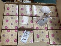 Box containing 12 boxed Precious Moments figurines with one figurine displayed on top showing packaging and quantity