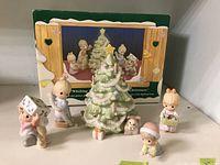 Photo showing the complete five-piece porcelain Precious Moments Christmas figurine set arranged in front of original box with displayed set image.