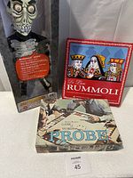 Full lot showing Achmed doll in box, De Luxe Rummoli game, and Parker Brothers Probe game box with instruction sheet
