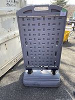 Rear view of the plastic sign holder showing the perforated backing, handle and base.