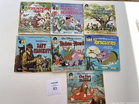 Photo of 7 vintage Disney read along record books displayed on a white surface showing full covers and characters