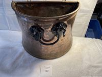 Front view of half copper tub showing cast iron handle and copper body