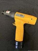 Side view of the yellow Atlas Coco Nut Runner Tool showing entire body, handle, and black tip