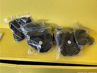 Six pairs of black moccasins individually bagged, sized 5 and small.