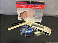 Photo showing all the office supplies: stapler, 3-hole punch, file pockets, ruler, tape dispenser, eraser, and pencil leads.