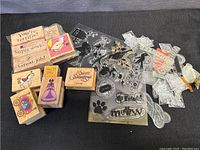 Rubber stamps laid out on black background showing both wooden mounted and clear silicone stamps