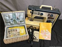 Brother sewing machine with controls, foot pedal, power cord, and manual on yellow booklet cover.