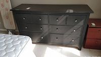 Front view of black Ikea dresser showing 8 drawers and overall condition