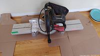 Full view of Craftsman compound miter saw placed on a cardboard sheet on wooden floor.
