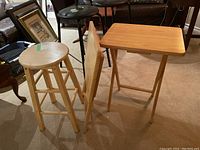 Wooden stool with two wooden TV tables on carpeted floor
